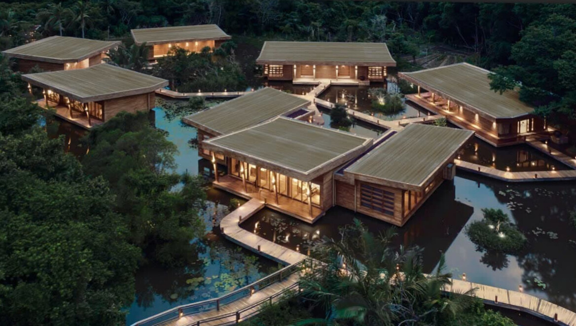 Luxury oceanfront wooden villas at Six Senses Con Dao resort surrounded by lush tropical greenery at twilight.